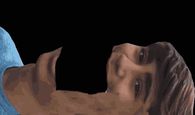 a man laying down with his mouth open and a woman standing in the background