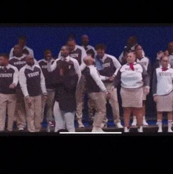 a group of people are standing on a stage wearing sweatshirts that say vboy .