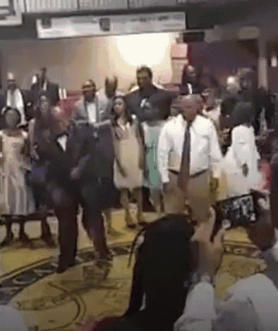 a group of people are standing in a room with a sign that says ' a ' on it