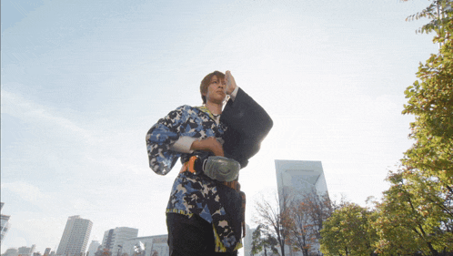 a man in a camouflage shirt is walking in a city