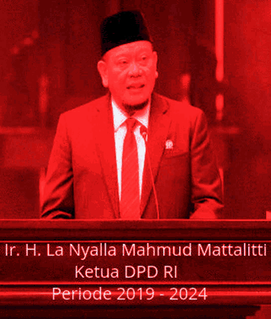 a man in a suit and tie stands at a podium with the name h. la nyalla mahmud mattalit on it