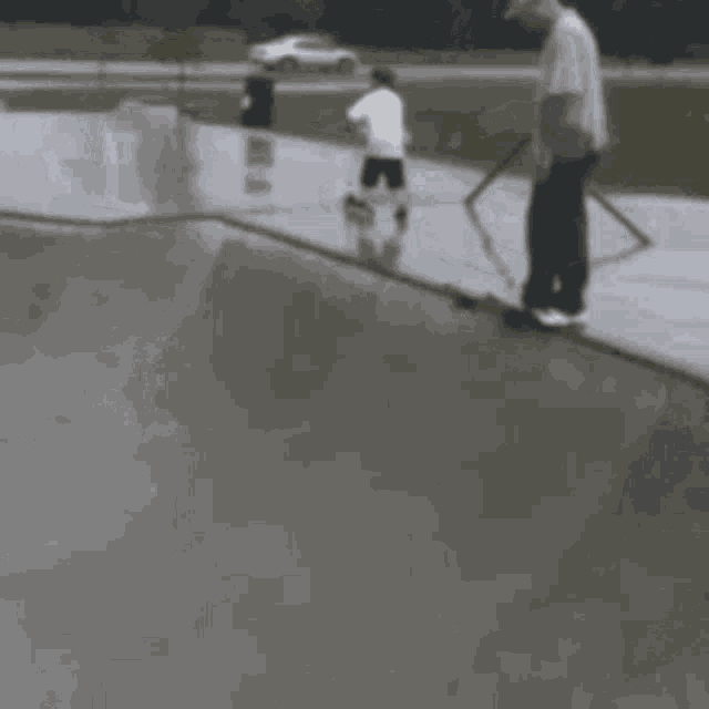 a man riding a skateboard down a ramp in a skate park