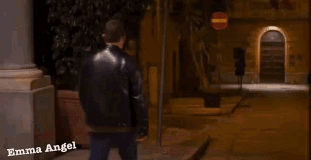 a woman walking down a street with the name emma angel on the bottom right