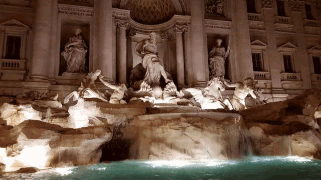 a fountain in front of a building with a statue of a woman on the side
