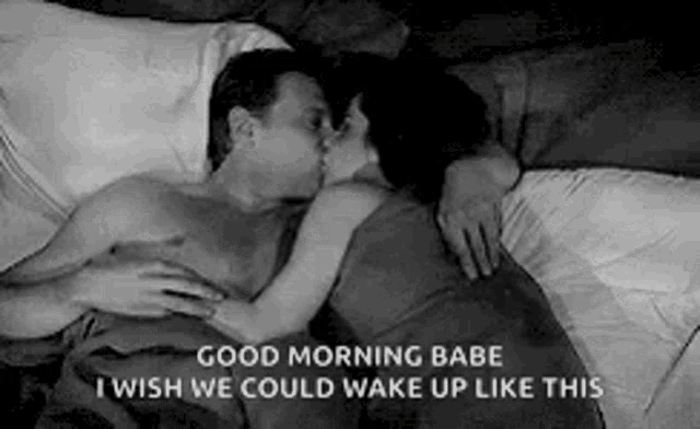 a man and a woman are kissing in bed and the man is without a shirt .