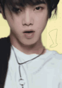 a close up of a young man wearing a white shirt and a black jacket .