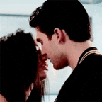 a man and a woman are kissing in a kitchen .