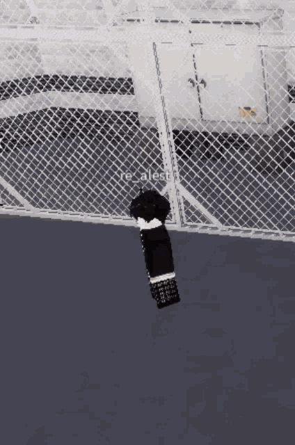 a person standing in front of a fence with the word realest written on it