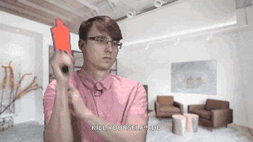 a man in a pink shirt is holding a red card that says kill yourself ddd