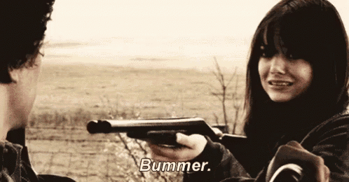 a man is pointing a gun at a woman who is holding a gun .