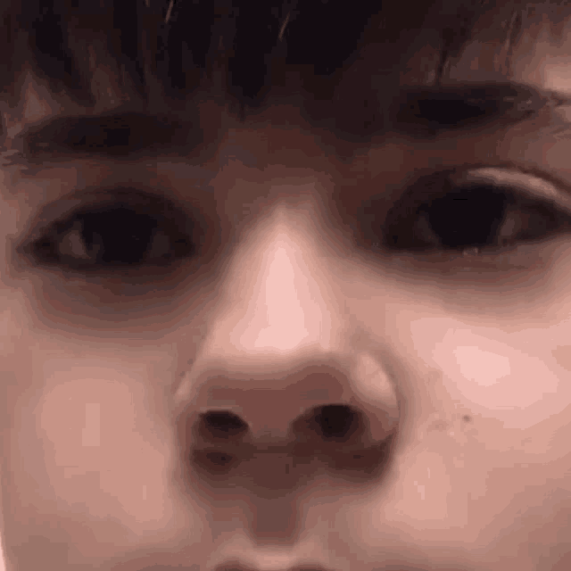 a close up of a young man 's face with his eyes closed .
