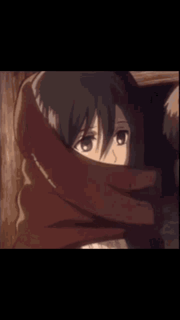 a girl is covering her face with a scarf