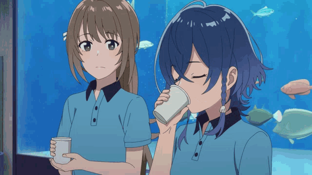 a girl drinking from a cup next to another girl