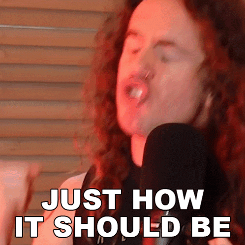 a man with long red hair is singing into a microphone with the words just how it should be above him