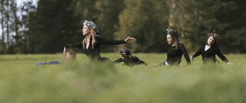 a group of women laying in a grassy field