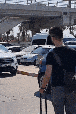a man holding a suitcase with a license plate that says 07 bae 485
