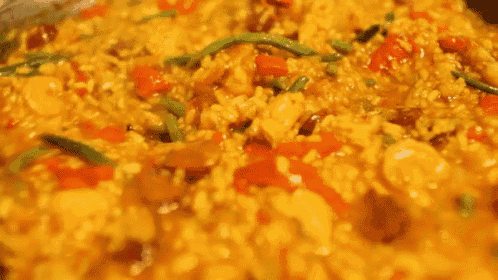a close up of a person stirring a pot of food with a fork .
