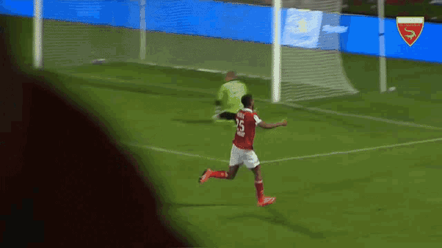 a soccer player with the number 25 on his jersey is running towards the goal