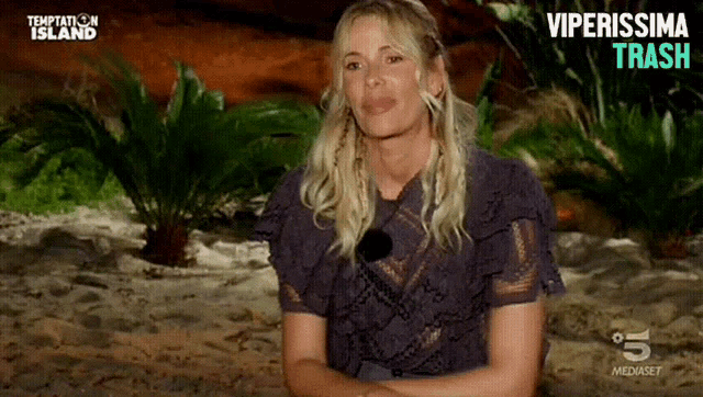 a woman is sitting on a sandy beach with temptation island written on the bottom