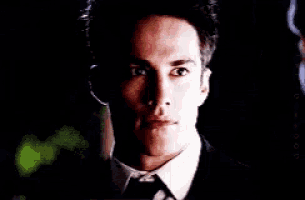 a close up of a man 's face in a suit and bow tie