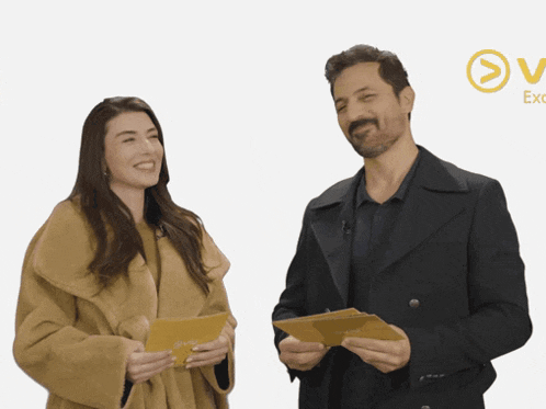a man and a woman are standing next to each other and the man is holding a piece of paper with the word excel on it
