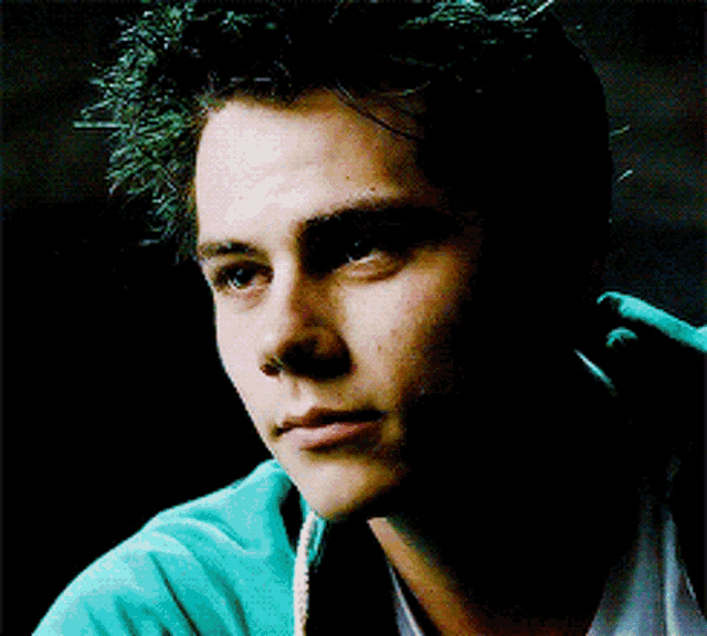a close up of a young man 's face in a dark room
