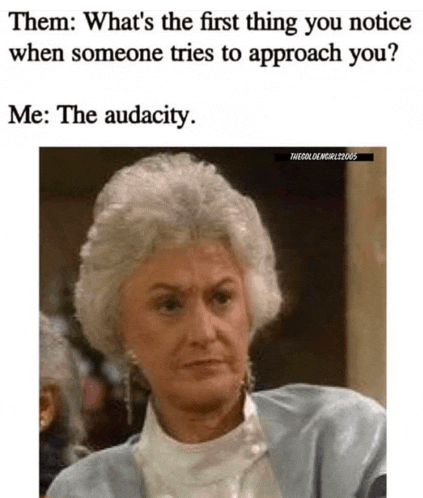 an older woman with gray hair is sitting in front of a mirror and talking to someone .