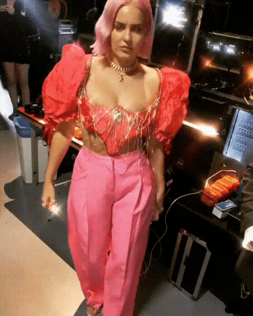 a woman in pink pants and a red top is walking