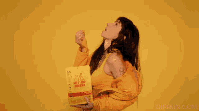 a woman in a yellow jacket is holding a bag that says ' gifrun.com ' on it