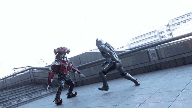 a man in a black suit is fighting another man in a red and black outfit