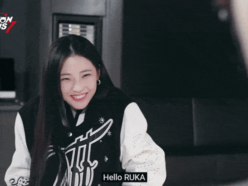 a girl is smiling in front of a sign that says on