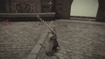 a person is standing on a brick floor in a video game with a sword in their hand .