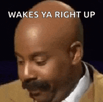 a bald man with a mustache is wearing a suit and tie and saying wakes ya right up .