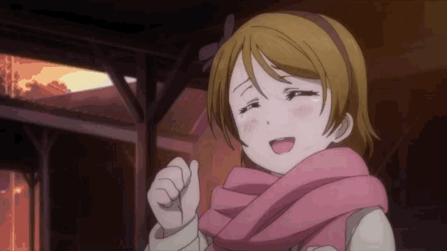 a girl wearing a pink scarf is making a face