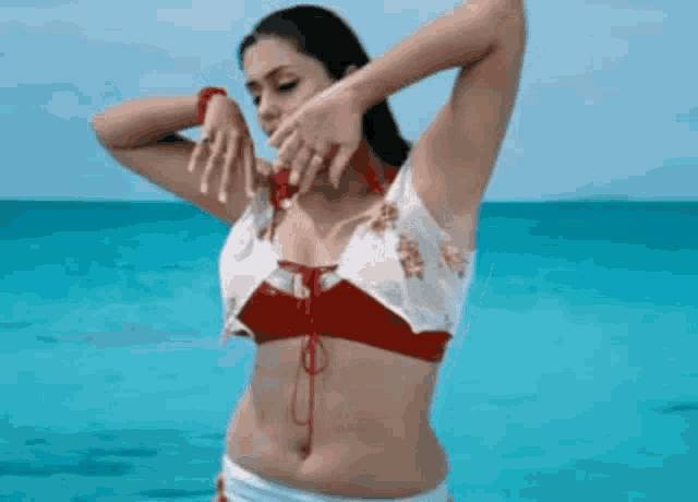 a woman in a red and white bikini is standing in the water
