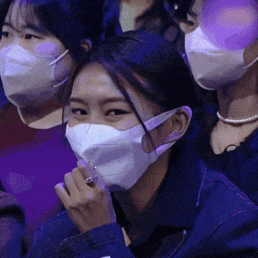 a woman wearing a face mask is smiling in a crowd
