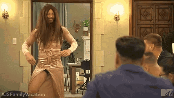 a man with long hair and a beard is dancing in a room with a mtv logo in the background