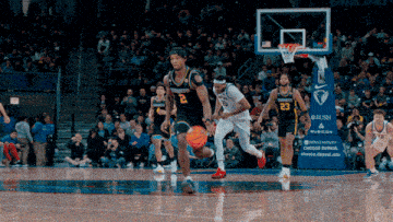 a basketball game is being played in front of a banner that says rush on it