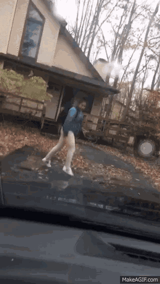 a woman is walking in front of a house with a backpack on her back