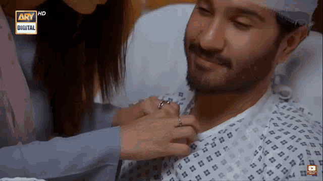 a woman putting a ring on a man in a hospital bed