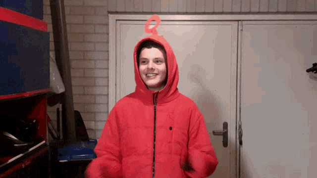 a person wearing a red jacket with a hood and a red ring on their ear