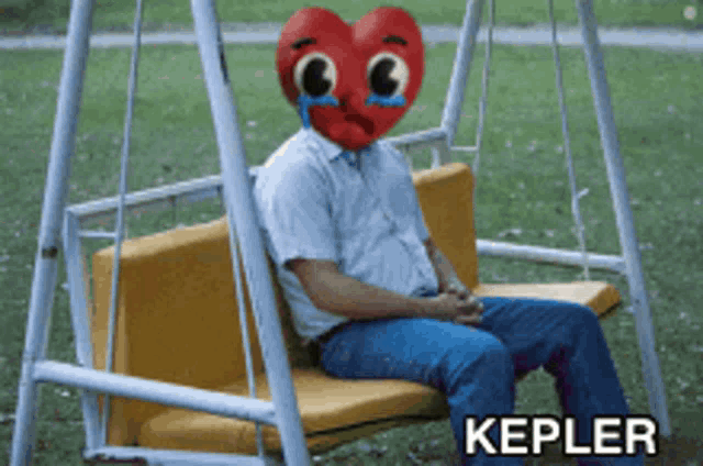 a man with a heart on his face is sitting on a swing with the word kepler on the bottom