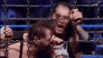 a man is chained to a fence and screaming .
