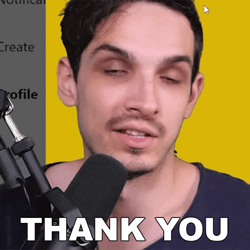 a man in front of a microphone with the words thank you on his face