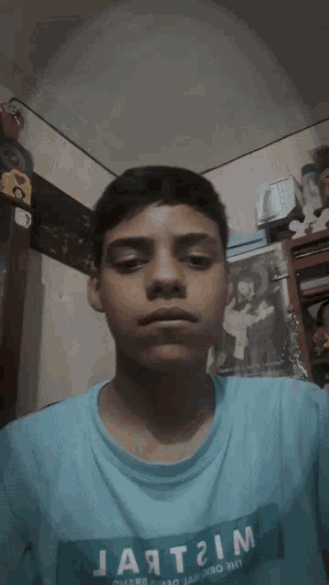 a man in a blue shirt is laying down in a room
