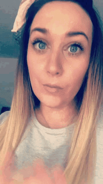 a close up of a woman 's face with blue eyes and blonde hair