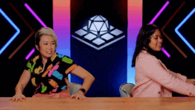 two women are sitting at a table with their hands on the table