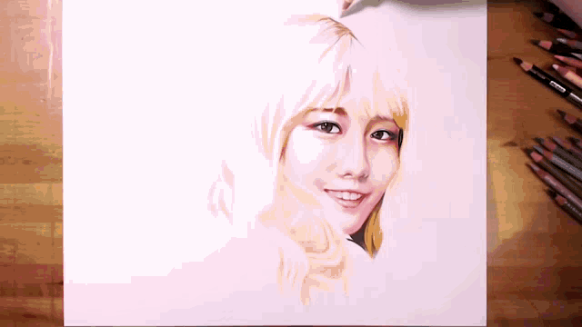 a drawing of a woman 's face is on a piece of paper with colored pencils