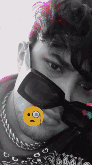 a man wearing sunglasses and a bandana with a smiley face on his face