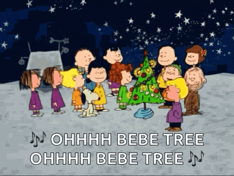 a group of peanuts characters are standing around a christmas tree and singing ohhhh bebe tree